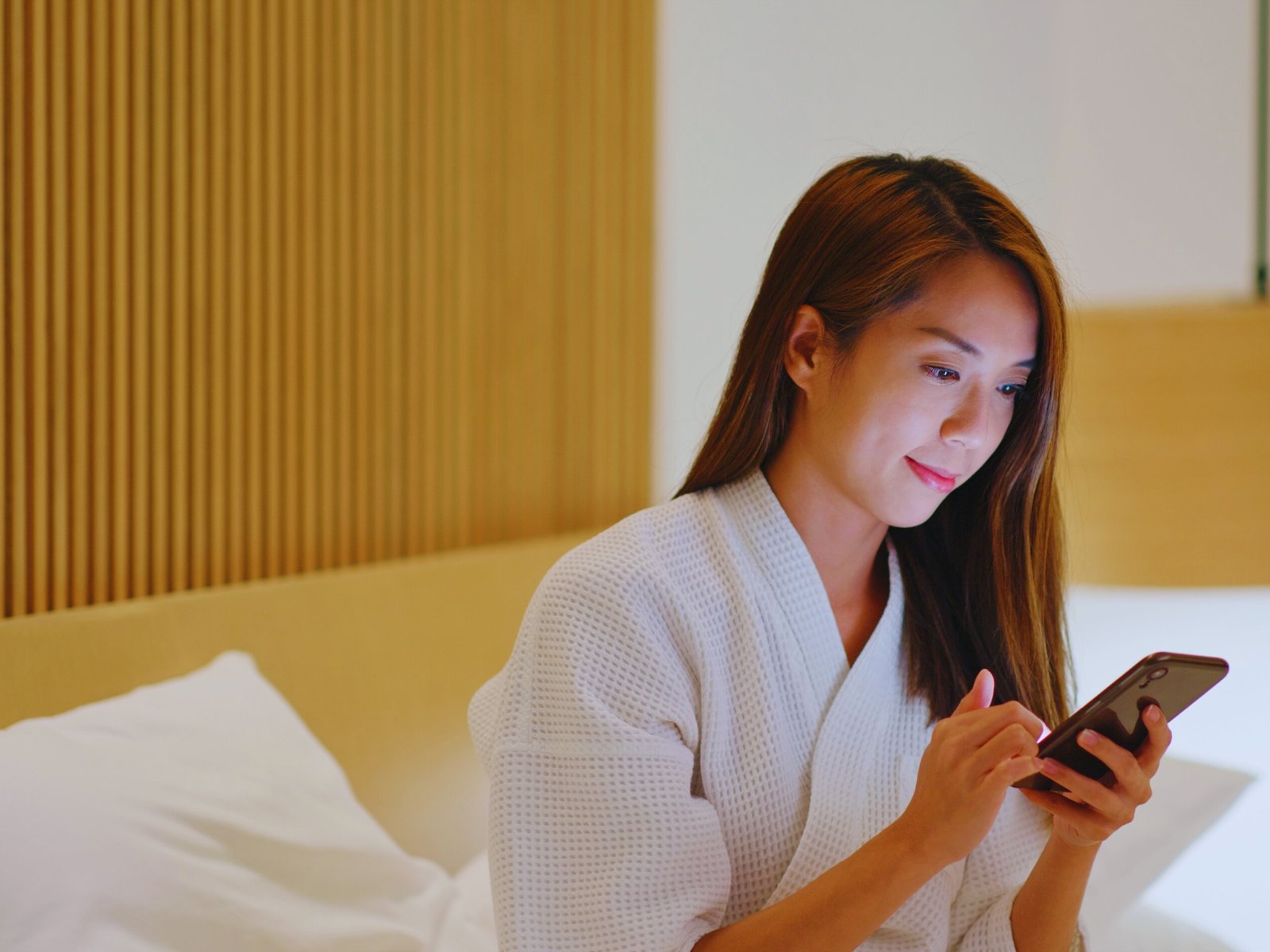 Donna in hotel guardando telefono con offerte a rimini